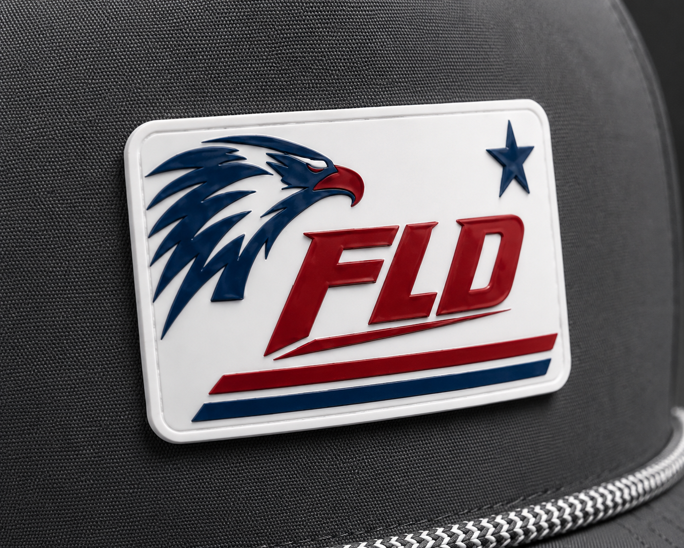 Close-up of FLD eagle logo acrylic patch on a gray Richardson 110 perforated rope snapback hat with raised red, white, and blue detail.
