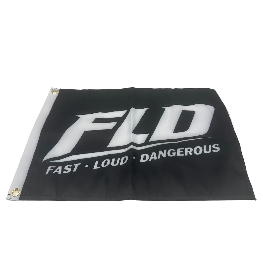 A black flag with a white printed logo reading 'FLD' and the words 'FAST • LOUD • DANGEROUS' underneath, photographed inside a light gray studio setup with reflective side panels.