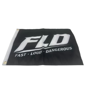 A black flag with a white printed logo reading 'FLD' and the words 'FAST • LOUD • DANGEROUS' underneath, photographed inside a light gray studio setup with reflective side panels.