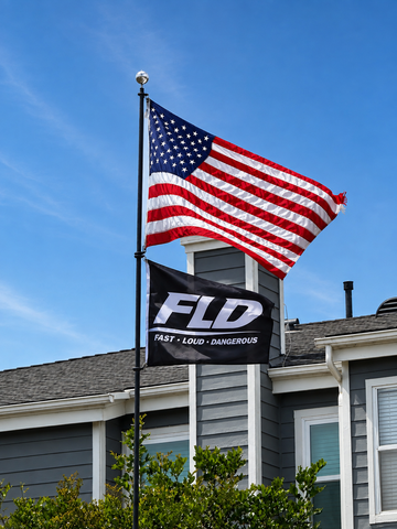 FLD black logo flag flying below an American flag outdoors