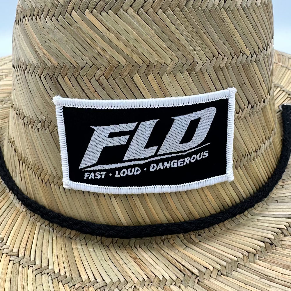 FLD straw sun hat with wide brim and front logo patch shown at a 45-degree angle on a white background.