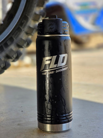 FLD 20 black  0z. water bottle sitting by motorcyce tire